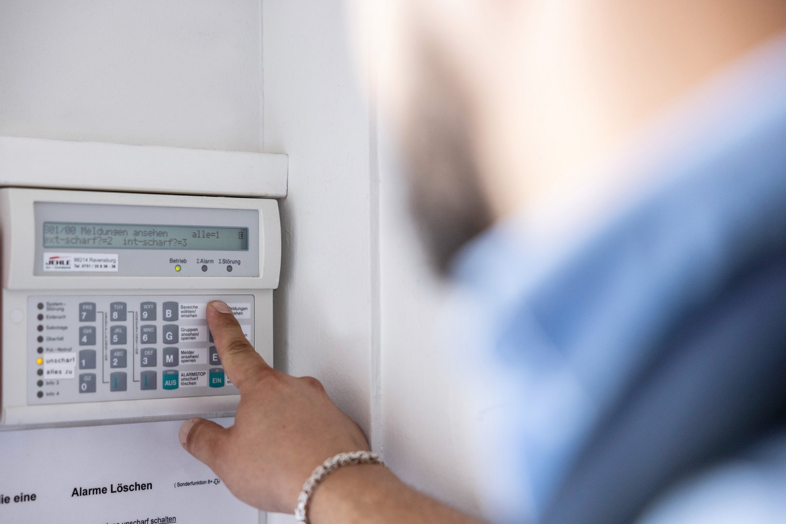 Sicherheitsmitarbeiter bedient Alarmanlage Nahaufnahme eines Sicherheitsmitarbeiters von CMS-Sicherheit, der eine Alarmanlage bedien